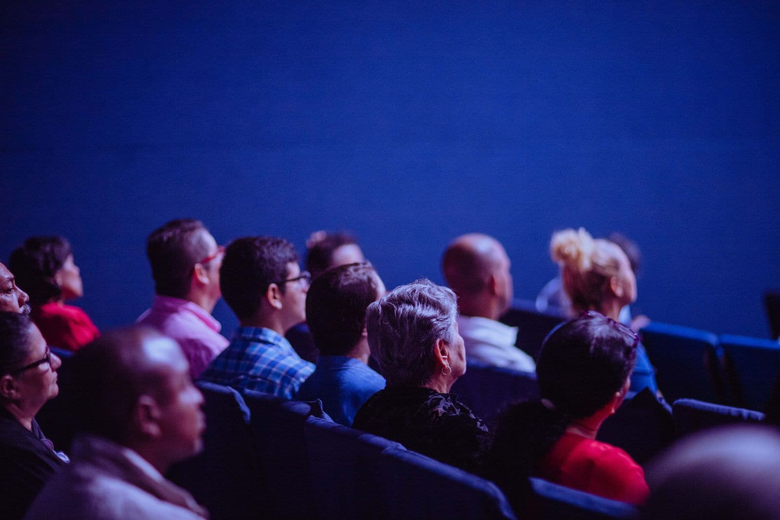A crowd of attendees seated and listening during a conference session