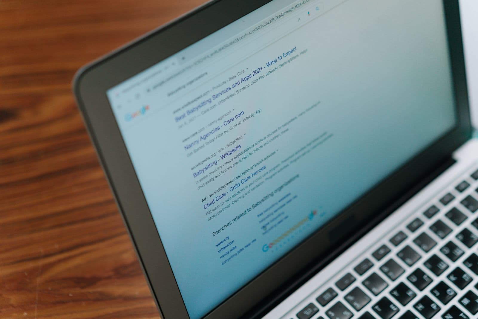 A laptop on a desk showing a search engine results page