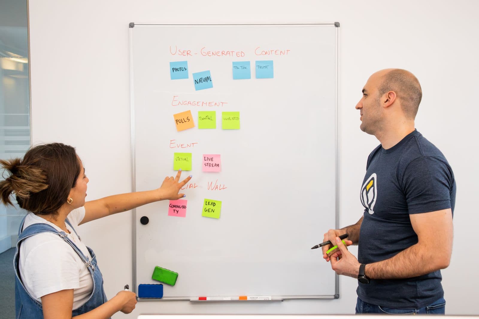 Two professionals mapping ideas on a whiteboard in an office