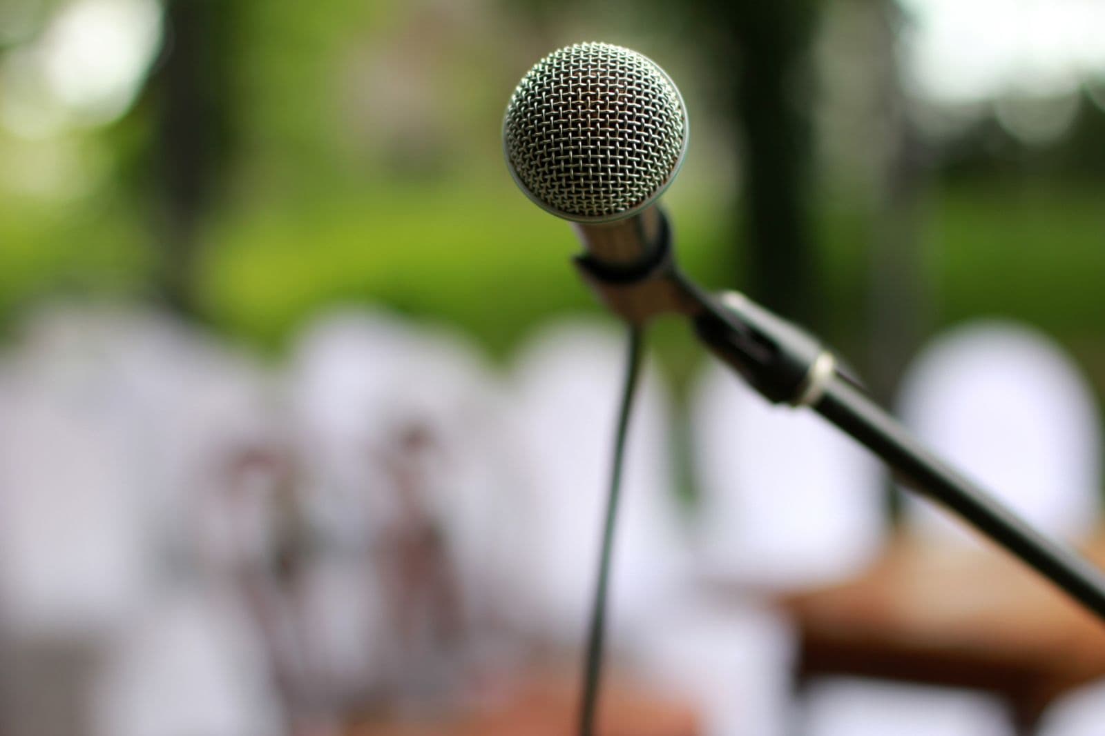 A studio microphone in sharp focus against a dark blurred background