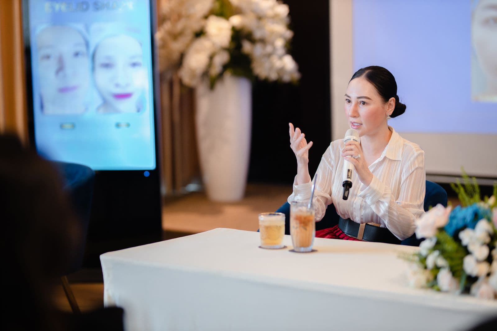 A businesswoman addressing an audience at a conference event