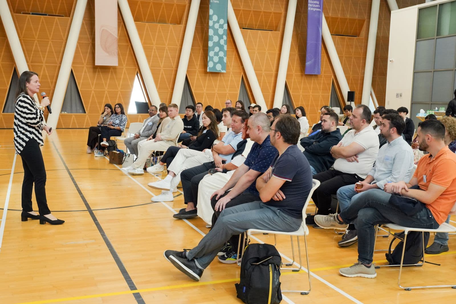 A speaker presenting to an attentive audience in a modern hall
